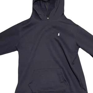 Marinblå hoodie från Ralph Lauren - // Snygg mörkblå hoodie från Ralph Lauren med det klassiska logotypbroderiet på bröstet. Storlek Small. Modellen är 178 och tröjan passar perfekt! // Hör av er vid fler funderingar /Quality Clothing!