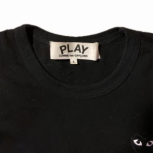 Svart långärmad tröja från Comme des Garçons - Säljer en stilren svart långärmad tröja från Comme des Garçons med det ikoniska hjärta-logotypen på bröstet. Tillverkad i 100% bomull, perfekt för en minimalistisk look. Passar bra till både jeans och chinos. Pris kan diskuteras vid snabb affär. Fråga gärna om fler bilder.