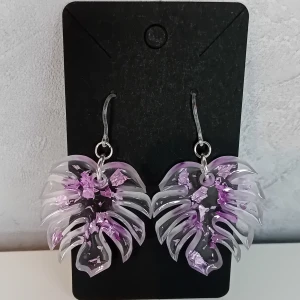 Egentillverkade genomskinliga örhängen med lila detaljer - Egentillverkade örhängen gjorda i resin. De är transparenta med lila detaljer. Öronkroken är gjord I plast. Längd ca 4.5cm
