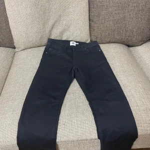 Svarta jeans från 157 - Snygga svarta byxor från 157 i storlek 160. Perfekta för en stilren look med klassisk design och bekväm passform. Byxorna har fickor både fram och bak.