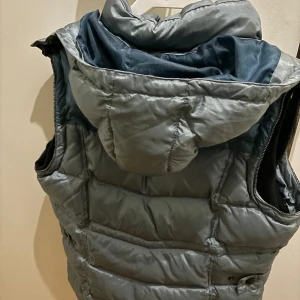 Grå dunväst från Mountain Horse - Snygg grå dunväst från Mountain Horse med dragkedja och praktiska fickor. Perfekt för kyligare dagar med en stilren design.