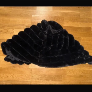 Svart pälsjacka i syntetmaterial - Elegant svart pälsjacka i syntetmaterial, perfekt för att hålla värmen under kyliga dagar. Jackan har en lyxig känsla med sitt mjuka och fluffiga material. Tillverkad av 100% polyester.