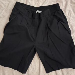 Svarta bomullsshorts - Snygga svarta shorts i 100% bomull med elastisk midja. Perfekta för en avslappnad stil.