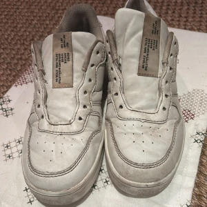 Vita sneakers - Säljer ett par vita sneakers med klassisk design. Skorna har perforerade detaljer på ovansidan och en bekväm sula. Perfekta för en avslappnad stil.