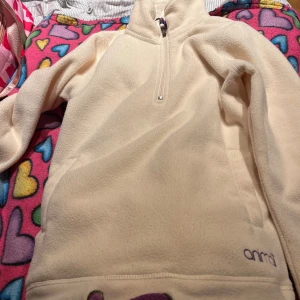 Beige fleece tröja från Animal - Mysig beige fleece tröja från Animal med halv dragkedja och fickor framtill. Perfekt för kyliga dagar. 💛