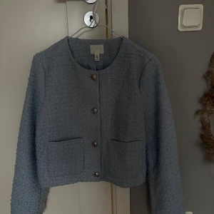 Blå kofta från H&M - Snygg blå kofta från H&M med rund hals och silver knappar framtill. 