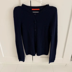 Kashmir kofta -  Costar Copenhagen - Säljer en stilren mörkblå kashmir koftan från Costar Copenhagen. Koftan har långa ärmar och knappar framtill, perfekt för lager-på-lager under kyliga dagar.