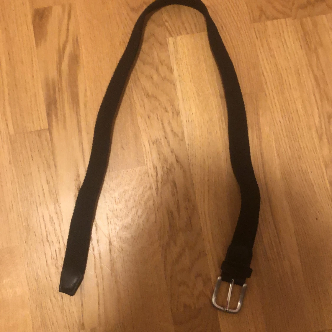 Svart bälte med silverfärgat spänne