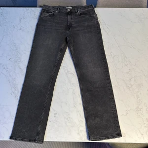 Svarta jeans från GANT - Snygga svarta jeans från GANT med klassisk design. De har en rak passform och är tillverkade i ett slitstarkt material. Perfekta för en stilren look. Pris kan diskuteras