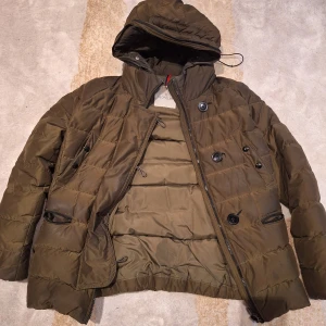 Moncler jacka - Säljer en använd moncler jacka, har mycket kvar att ge. Några vita fläckar men inget som stör användningen. En knapp är lite lös men går att fixa med tråd. 