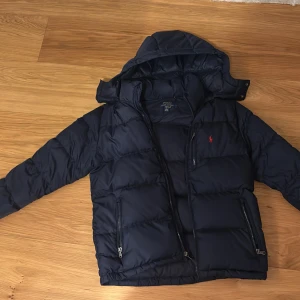 Mörkblå dunjacka från Polo Ralph Lauren - Säljer en snygg mörkblå dunjacka från Polo Ralph Lauren i storlek är det 14 till 16 år