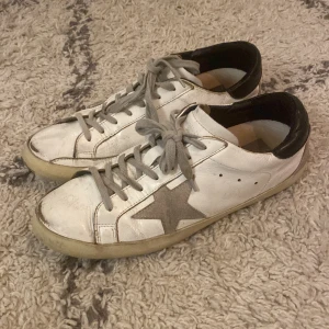 Goolden goose skor  - Hej, säljer nu dessa feta goolden goose skor.  Perfekta för hösten och kommande våren! Har andvänt dom ganska mycket och nu är dom för små. Nypris 8000kr. Dom är ganska slitna, har lämnat in dom till en skomakare en gång som fräschade upp dom och fixade sulan. Om man kollar väldigt noga kan man se mycket lite spår av limning på undersidan av skon. Skick 5/10. Vi frågor skriv Järna! 
