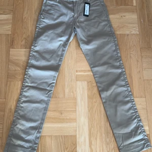 Beige chinos - Snygga beige chinos i nytt skick. De har en klassisk straight passform. Nyskick och aldrig använda. Finns i andra storlekar också. 