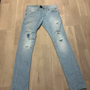 Ljusblå jeans Dondup 29/32 - Säljer ett par ljusblå jeans från Dondup. De har en snygg slitning på benen som ger en cool och avslappnad look. Perfekta för vardagsbruk eller en casual utekväll. De är i bra skick och redo för en ny ägare!