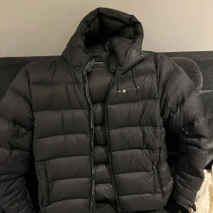 Sail racing jacka - Sail racing gravity down jacket i svart. Fin jacka som håller sig varm på vintern. Använda några säsonger så loggan har börjat komma av som ni ser på ena bilden. Köpt för 3499, storlek M