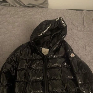 Svart glansig dunjacka från Moncler - Fint o nytt skick. Betalas med swish till mig eller min kollega. 