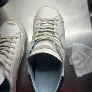 Vita Philippe Model Sneakers strl 42 - Säljer ett par vita sneakers från Philippe Model. De har en klassisk design med snörning och är i bra skick, men med lite smuts på sulan. Kommer med allt OG förutom nya snören, öppen för byte. Kontakta vid minsta fråga🤝