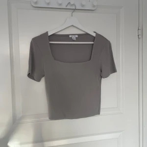 Grå topp från New Yorker  - Grå tight T-shirt från New Yorker med fyrkantig ringning 