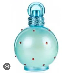 Parfym i blå flaska med röda stenar - Säljer en cool parfym i en rund, ljusblå flaska med röda stenar. Flaskan har en glittrig blå ring runt halsen och ett matchande blått lock. Perfekt för att piffa upp din parfymkollektion! 💙 Nästan helt full.