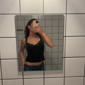 Svart korsett med pärlor - Snygg svart korsett med pärlor. Någon pärla saknas. Men inget man märker. 