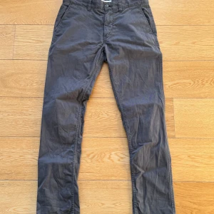 Grå chinos från NN07 - Storlek 31/32 - Säljer ett par stilrena grå chinos från NN07 i storlek W31 L32. De är tillverkade i 99% bomull och 1% elastan vilket ger en skön passform. Perfekta för både vardag och fest! 🕺
