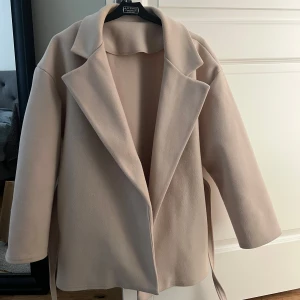 Kappa - Säljer en superfin Missäy kappa i mycket bra skick. Den har en stilren design med ett knytbälte i midjan och långa ärmar. Perfekt för höst och vår när du vill se chic ut utan att frysa. Passar både till vardags och festliga tillfällen!