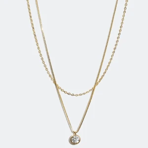 Halsband  - Dubbelhalsband i äkta silver förgyllt med 18 karat guld med en ankarkedja och en längre venetiansk kedja som är dekorerad med ett hänge av en rund Cubic Zirconia sten. Ett stilrent halsband med skimrig detalj som passar både till vardags och till fest. Kedjorna fäster i samma spänne och kan inte användas separat. Sparsamt använd