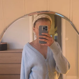 Ljusblå ribbad kofta från Gina Tricot - Säljer denna drömmiga ljusblå ribbad kofta från Gina Tricot. Koftan har en v-ringad design med knappar framtill och långa ärmar. Perfekt för skolan/jobbet eller till festliga tillfällen när man vill känna sig bekväm💙