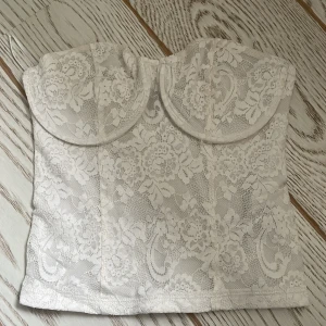 Vit spetskorsett - Elegant vit korsett med vacker spetsdesign . Perfekt för en stilfull look. Baksidan har elastisk smock för bättre passform. Aldrig använd 