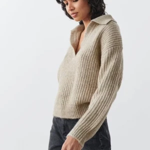 Beige stickad tröja med krage - Säljer en stilren beige stickad tröja med krage och v-ringning. Tröjan har långa ärmar och en ribbad struktur som ger en snygg passform. Perfekt för kyligare dagar. Inköpspris 359kr 