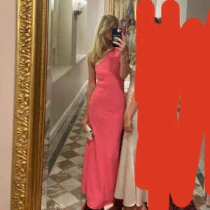 Rosa balklänning med oneshoulder - Säljer en elegant rosa långklänning med oneshoulder-design. Perfekt för speciella tillfällen med sin stilrena och moderna look. Klänningen har en smickrande passform och är tillverkad i ett mjukt material som faller fint. Superfint skick💕