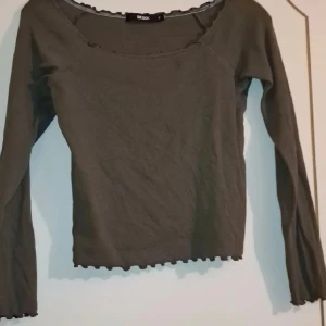Militärgrön långärmad topp i storlek M - Militärgrön långärmad topp från BikBok. Den är i ribbat tyg och väldigt stretchig med fina volanger. Använt 1 gång. Skickar alltid inom 24 h på vardagar.