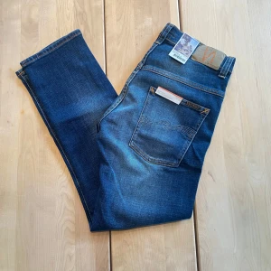 Helt nya Nudie Jeans -  Tjena! Säljer nu ett par riktigt feta nudie jeans med en riktigt snygg tvätt. De är HELT NYA, med lapparna fortfarande kvar. Jeansen är i modellen ”Thinn Finn”, vilket är en slim fit passform. De är ju som sagt helt nya, så finns inga defekter. De är i storleken ”31/28”. Hör av er vid närmsta fundering.  ❗️Kolla även in min profil för fler helt nya nudie jeans i olika storlekar❗️