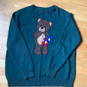 Grön tröja med björnmotiv från Minga London - Mörkgrön stickad tröja från mingalondon med en Björn på. Använd 1 gång, passar M men också S🫶