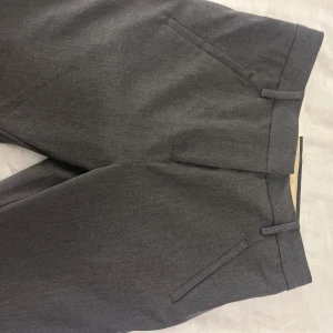 Oanvända gråa kostymbyxor Five units  - Helt oanvända kostymbyxor från five units i modellen Angelie. Medium rise, storlek 24 (se bild) i jätte skönt material. Nypris 1500, säljes för 900 frakt ingår. 