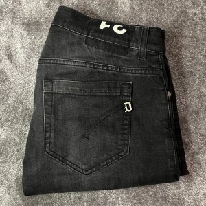 Svarta jeans från Dondup - Snygga svarta jeans från Dondup i den populära modellen ”George”.  En liten defekt som går att laga (be om bild). Perfekta för en stilren look. Gjorda i italien så väldigt bra och kvalitet! Pritet går möjligtvis att diskutera vid snabb affär! Mvh Lh. 
