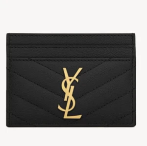 Svart kortfodral från YSL - Snyggt svart kortfodral från YSL i skinn med quiltad design. Det har ett elegant guldemblem på framsidan. Perfekt för att hålla dina kort organiserade med stil.