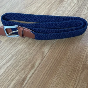 Flätat bälte  - Jag säljer ett blått flätat bälte som endast är testat en gång och är i ny skick. Det är 105 cm långt och är köpt från Jack and Jones. Nypris 200kr. Skriv för fler bilder eller minsta funderingar. Pris kan diskuteras.