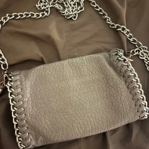 Tiamo väska  - Grå liten tramp väska 