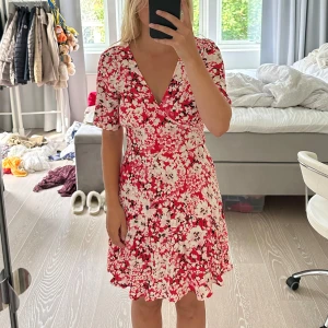 Blommig röd klänning Vila - Klänning från Vila i storlek M. passar S också. Blommigt mönstrad vit, röd och svart. den är i mycket bra skick!