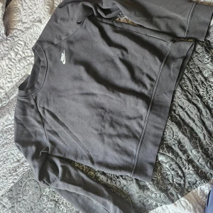 Svart tröja från Nike - Säljer en svart tröja från Nike i storlek S. Den är perfekt för både vardag och träning. Tröjan har långa ärmar och är i ett mjukt material som känns skönt mot huden. Den har en klassisk Nike-logga på bröstet. Passar perfekt till höst och vinter!