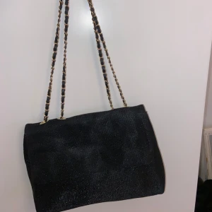Svart väska med guld detaljer 👜👜 - En jättefin helt oanvänd svart väska med glitter och guldkedja! Så sjukt fin och är en jättebra skolväska och fest 💕💕🥰säljer då jag har för många väskor 