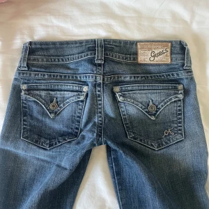 Lågmidjade jeans Guess - Säljer dessa superfina lågmidjade jeansen från guess. Älskar dessa men de passar mig tyvärr inte. Midjemått rakt över: ca 35cm, innerbenslängd: ca 79cm. Tar emot bud för högre än 550 men inte mindre💕