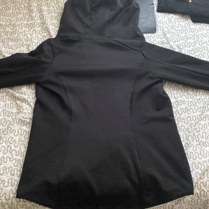 Svart zip-hoodie/idrotts hoodie med huva - I väldigt gott skick, inte smutsig alls. Zippen funkar, det är en sports ziphoodie. Huva stor nog och sitter inte tajt. Den visar din kropps figur/form bra och är flis inuti så du fryser inte men behöver även inte svettas i den.