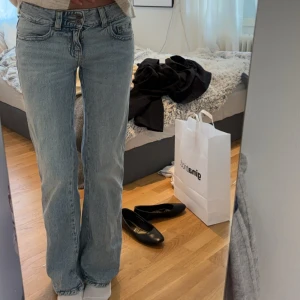 Ljusblå bootcut jeans - Säljer ett par snygga ljusblå bootcut jeans. De har en klassisk femficksdesign och är perfekta för en avslappnad stil. Jeansen är lågmidjade och har en bekväm passform. Perfekta för både vardag och fest!