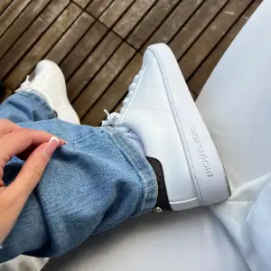  Michael Kors sneakers med den klassiska Bruna loggan på baksidan. Super fina med en klänning när man inte vill ha klackskor och med shorts och Jeans! Storlek 36 och en halv med passar mer en 36.  Använda en gång i 1 timme. 