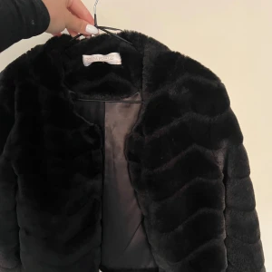 Fuskpäls - Jacka i fuskpäls. Svart. Stel XS
