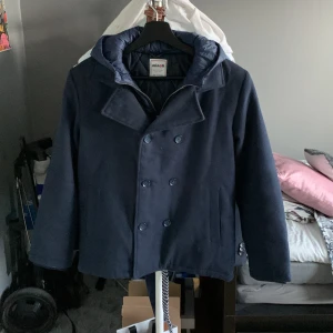 Dubbelknäppt skeps rock - Miinoti vinterjacka. Andvänd en vinter och är k nyskick, med innerdragkedja se bild. Den har luva men som går att vika bort. Halsduk kan skickas med för 50 kr extra! Den sitter större än storleken visar!!