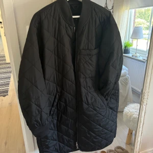 Höst/vårjacka - En svart tunnare jacka med mönster som är perfekt till vår/höst. Fickor samt en liten bröstficka, sparsamt använd så i fint skick förutom lite noppror uppe vid kragen och muddarna vid armarna. Passar L/XL.
