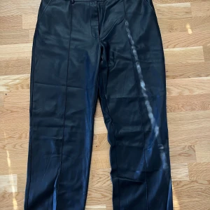 Skinnbyxor - Nakd  - Säljer ett par svarta skinnbyxor i storlek 44 från Nakd. Mycket gott skick, använda fåtal gånger! Utsvängda/raka ben. 